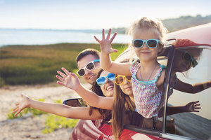 Happy family wearing sunglasses in a car