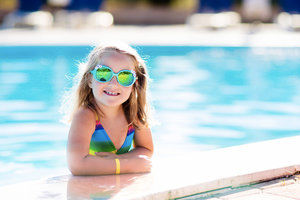 Little girl in a pool wearing sunglasses