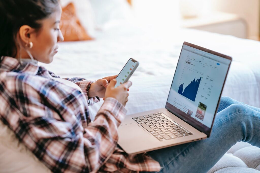 Woman with laptop looking at her phone